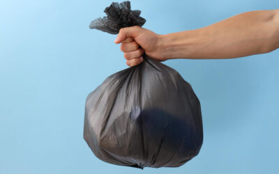 mão segurando saco de lixo