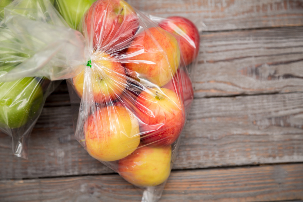 duas sacolas plásticas com frutas dentro